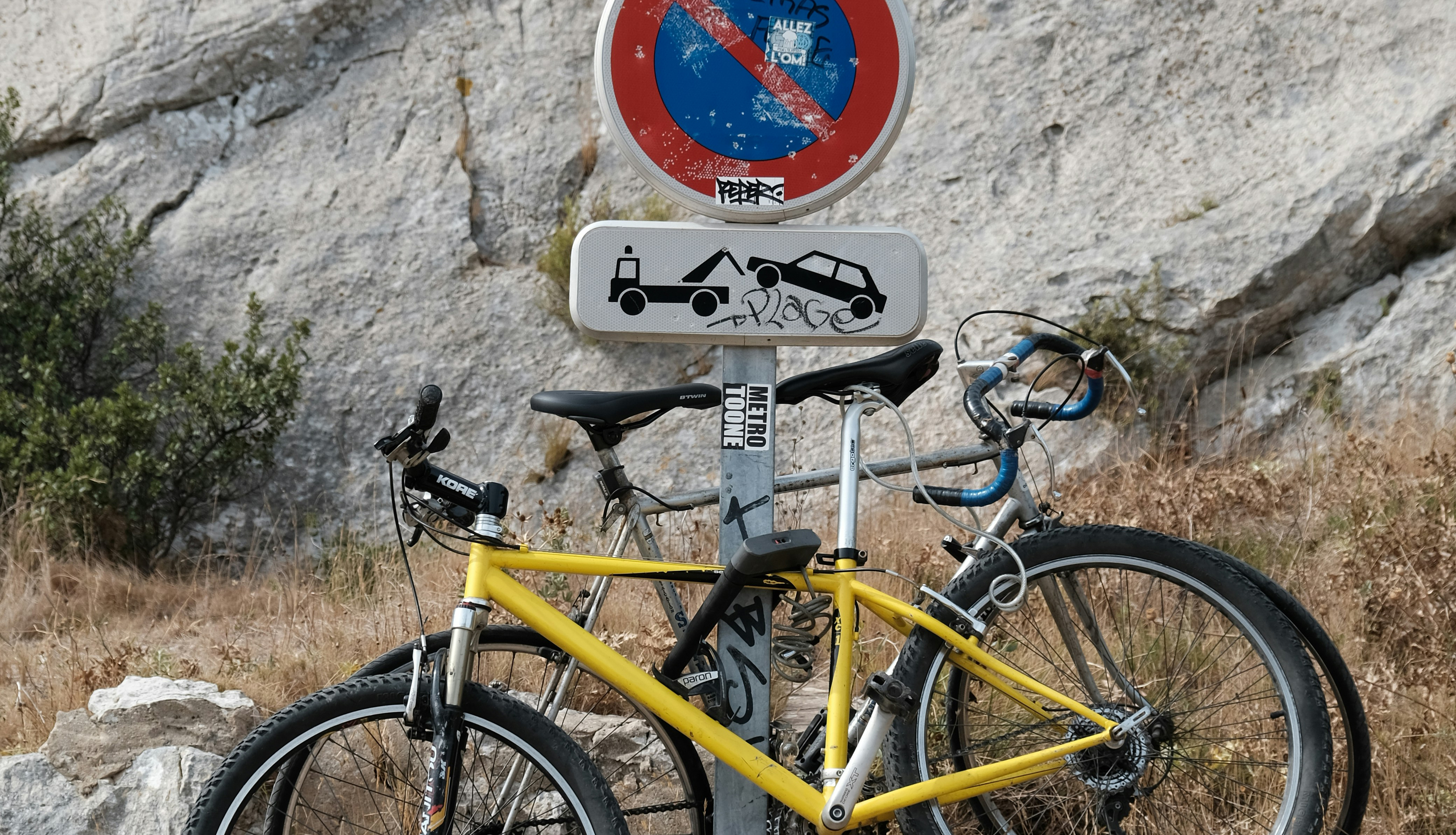 Un vélo est accroché sur un panneau de signalisation au bord d'une route